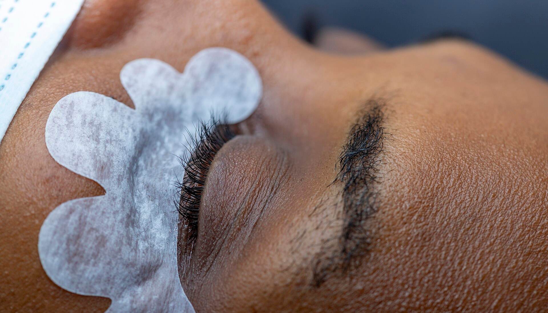 Pestanas e sobrancelha de perfil, com o protetor de gel por baixo dos olhos antes da aplicação